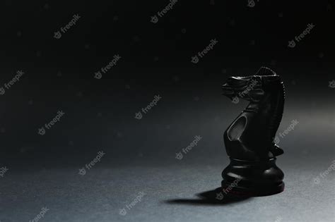 Premium Photo | Black wooden chess knight on dark background space for text