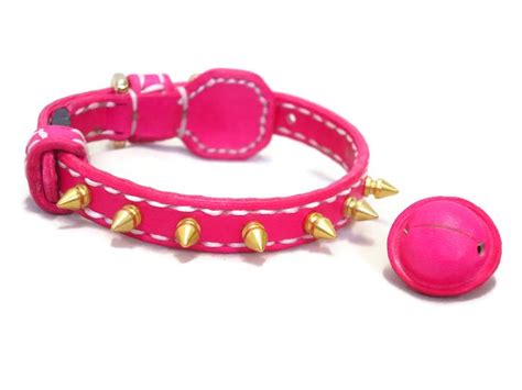 a pink dog collar with spikes and a ball