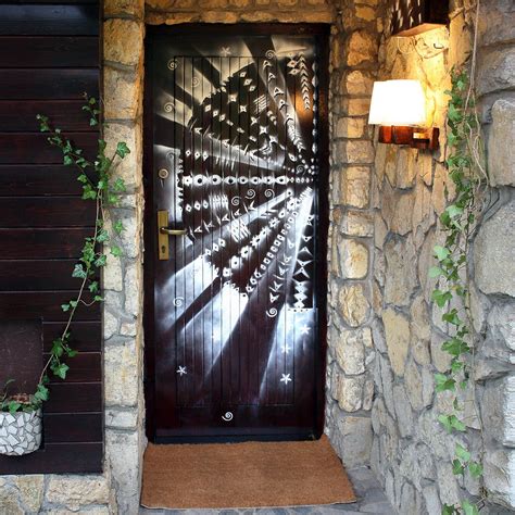 A Door With An Artistic Design Painted On It And Some Plants In Front Of It