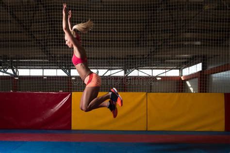 Atleta Performing Un Salto De Longitud En Gimnasio Imagen De Archivo