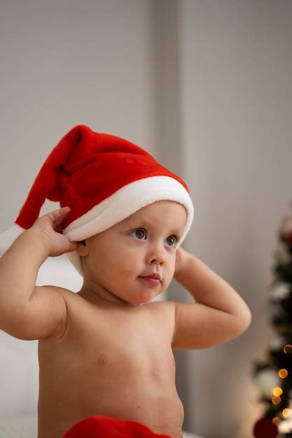 Bebê de tiro médio usando chapéu de papai noel Foto Grátis