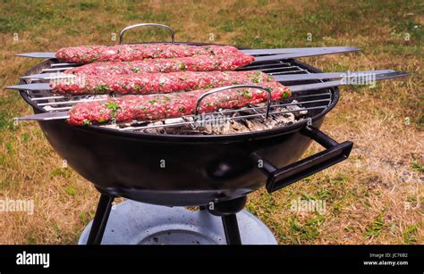 Shish Kebab Prepared Over A Black Round Shaped Charcoal Barbecue