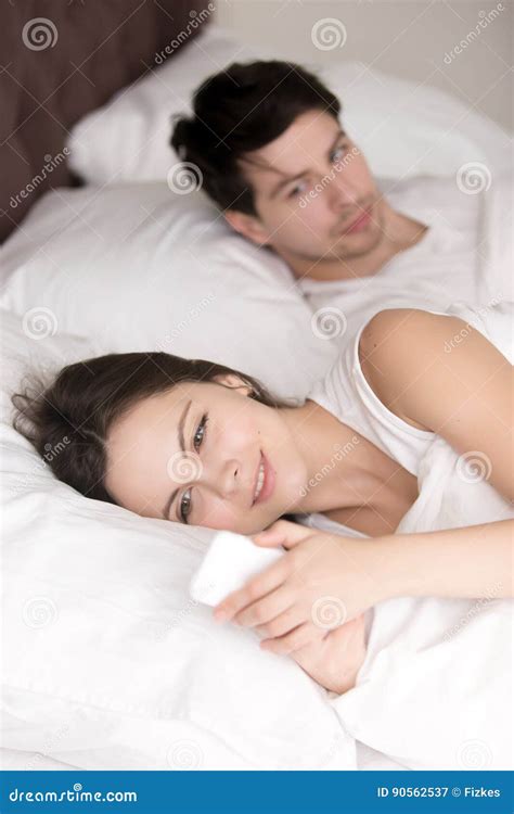 Worried Man Suspecting His Girlfriend Cheating Using Cellphone I Stock