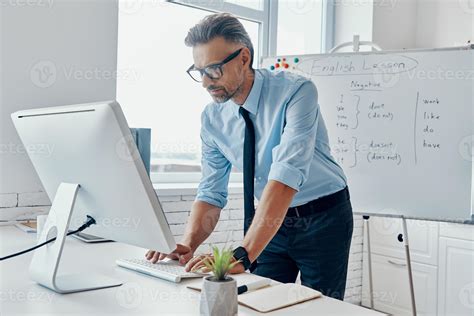 Confident English Teacher Using Computer While Standing Near The