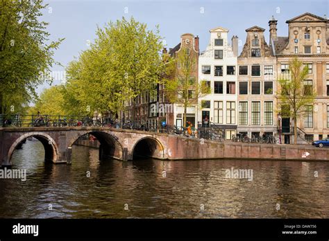 City of Amsterdam bridge on a canal and traditional Dutch houses ...