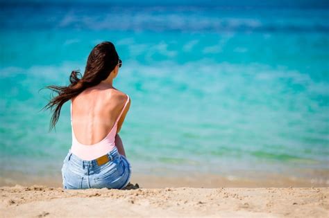 Mulher deitada na praia aproveitando as férias de verão olhando para