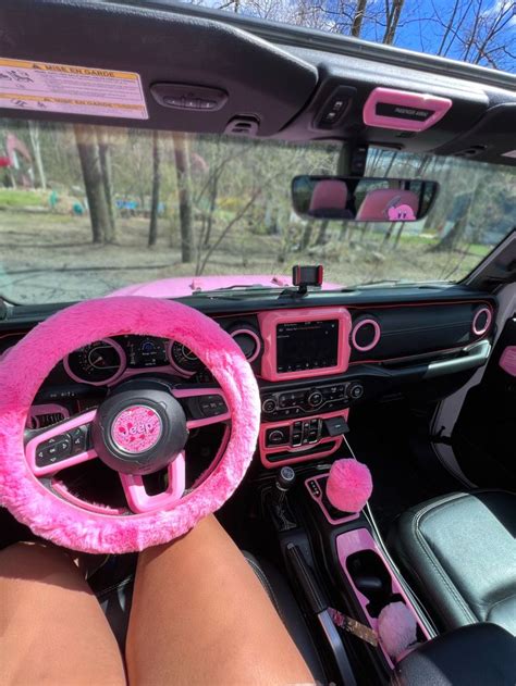 a pink steering wheel cover sitting on the inside of a car's dash board