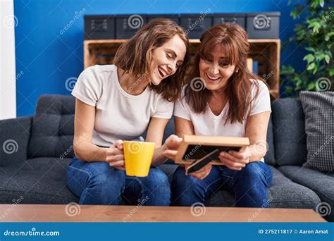 Two Women Mother And Daughter Drinking Coffee Looking Photo At Home