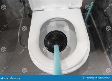 Toilet Repair by Hand with a Toilet Plunger. Plumbing. a Plumber Uses a Plunger To Unclog a ...