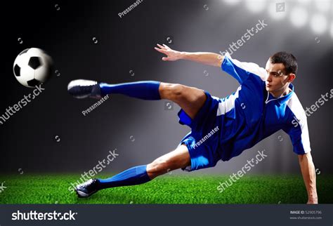 Image Of Soccer Player Doing Flying Kick With Ball On Football Field