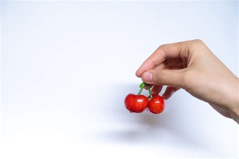 Person Holding Red Cherries · Free Stock Photo