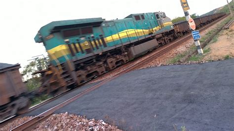 Trem cargueiro de minério de ferro descendo lotado a todo vapor após