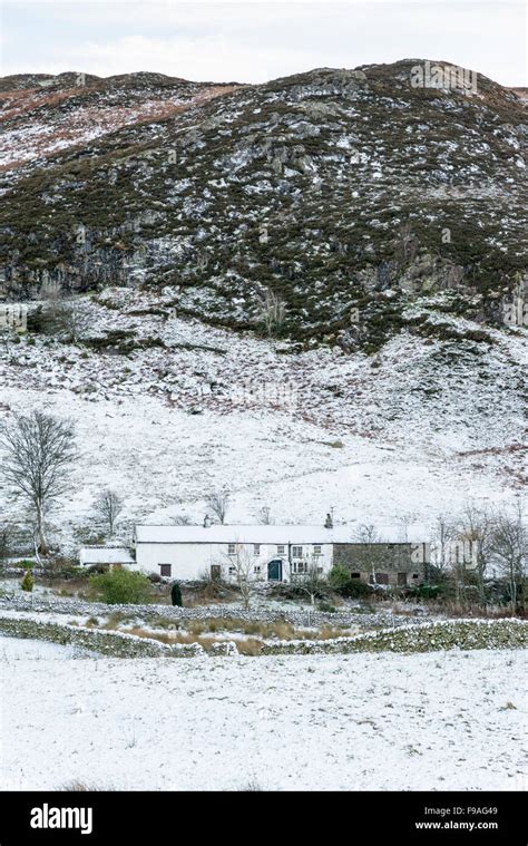 A Snowy Landscape Of Cumbrian Farms Buildings And Mountains Near