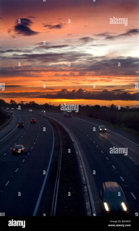 Road traffic on the M5 motorway at sunset, near Dursley ...