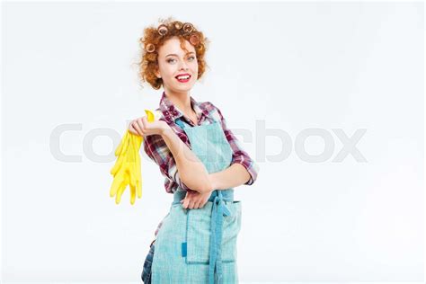 Cheerful Housewife In Blue Apron Holding Yellow Rubber Gloves Stock