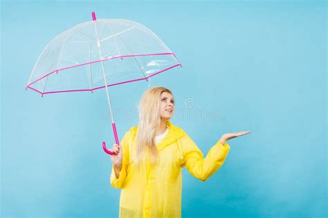 Woman Wearing Raincoat Holding Umbrella Checking Weather Stock Photo