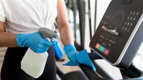 Free Photo Woman With Gloves At The Gym Disinfecting Equipment