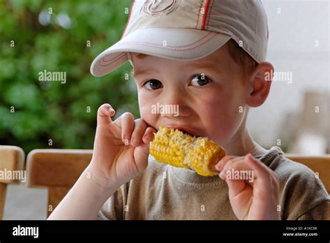 Little Boy Is Eating A Barbecue Corn Cob Stock Photo Alamy