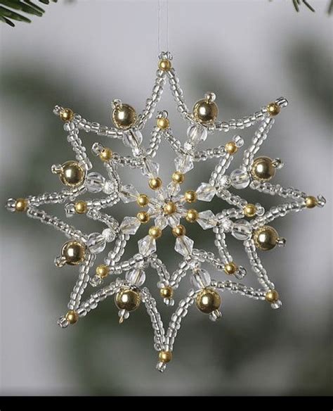 A Snowflake With Gold And White Beads On It