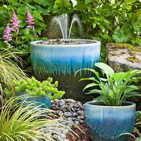 Three Planters With Plants In Them And Water Coming Out Of The Top One