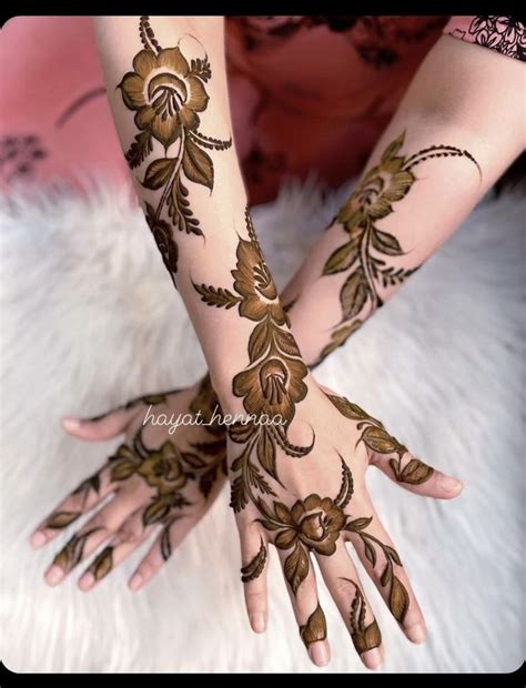 Two Hands With Henna Tattoos On Them