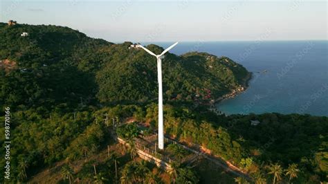 Wind Turbine Towering Over Hill With Stunning Ocean View Large Wind Turbine With Blades On