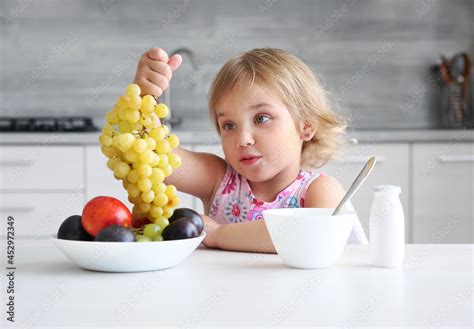 Child girl eating fruits. Little girl have a healthy meal at kitchen ...