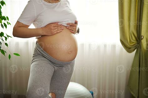 Close Up Pregnant Woman With Naked Belly Practicing Yoga Tree Pose At