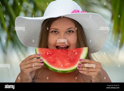 Junge Hübsche Blonde Frau Am Strand Unter Palmen Trägt Hut Und Isst