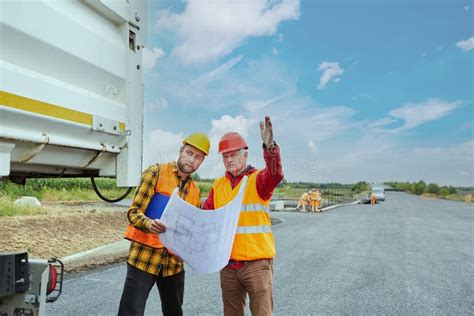 Trabajador En Obra Con Carretilla Llena De Hormigón Imagen de archivo