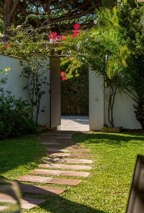 A Small Garden With Grass And Flowers In The Background