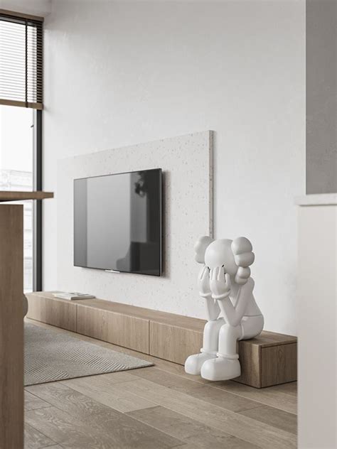 A Living Room With A Television Mounted On The Wall And A Statue In