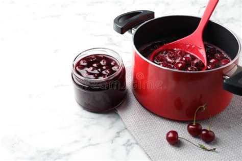 Pot With Cherries In Sugar Syrup On Marble Table Making Delicious Jam