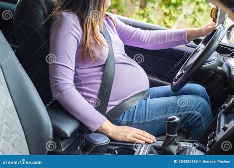 A Pregnant Woman Wearing A Seat Belt Drives A Car Safety And Driving During Pregnancy Stock