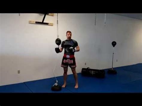 A Man Standing In Front Of A Punching Bag With Boxing Gloves On His