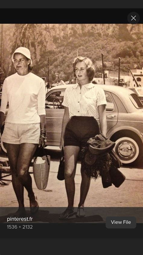 An Old Black And White Photo Of Two Women Walking