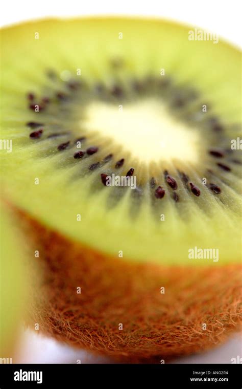 Close Up Of Single Kiwi Fruit Cut In Half On White Background At Angle