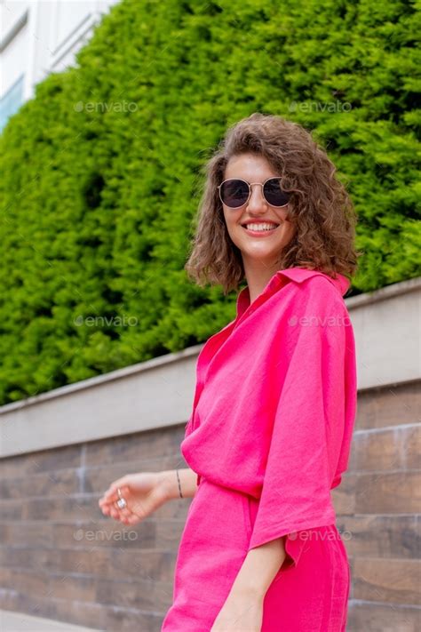 Candid Portrait Of Beautiful Young Woman In Bright Pink Shirt On Nature