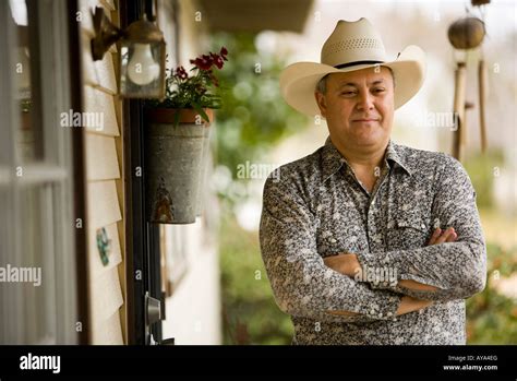 View Of A Contemplative Mature Man Wearing Cowboy Hat In Front Of House