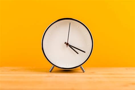 Premium Photo Alarm Clock On Yellow Background Time Concept