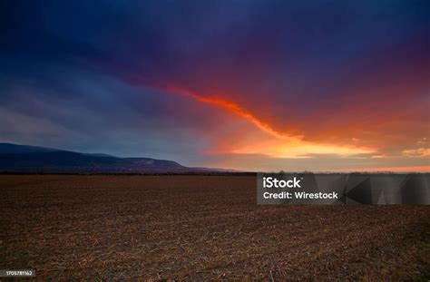 Desolate Landscape With A Barren Field And An Overcast Sky With Thick