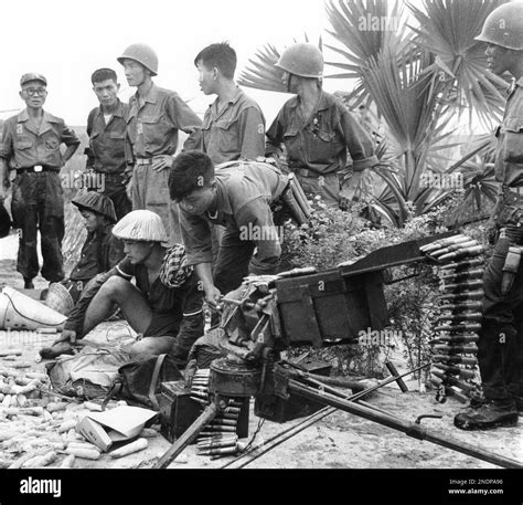 Two Viet Cong Guerrillas Sit On The Ground With Captured 50 Caliber