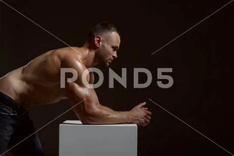 Male Muscular Athlete Poses At The Cube In Studio Stock Photo