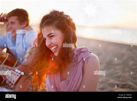 Smiling woman sitting on beach Stock Photo - Alamy