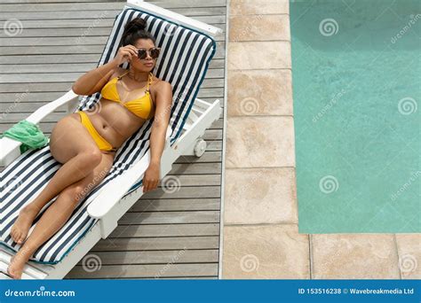 Woman In Bikini Relaxing On A Sun Lounger Near Swimming Pool Stock