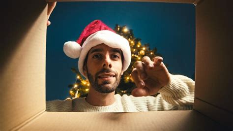 Chico Feliz Abre Y Mira Dentro De Una Caja De Navidad Foto Premium