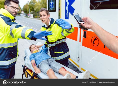 Paramedics Fighting People Trying To Make Photos Of Accident Stock