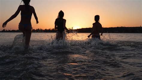 Happy Wet Girls Silhouettes In Bikini Have Fun Splashing Water To Each