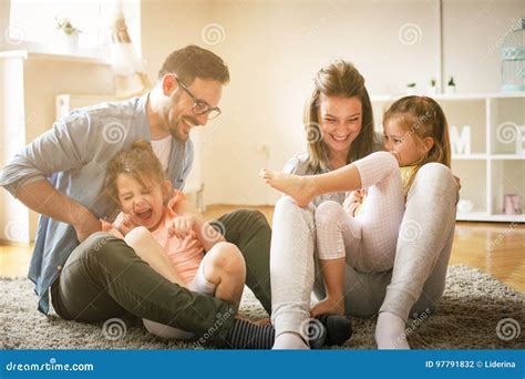 Familia Feliz Con Dos Hijas Que Juegan En Casa Foto De Archivo Imagen