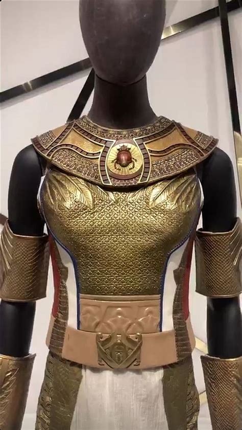 A Mannequin Dressed In Gold And White With Armor On It S Chest